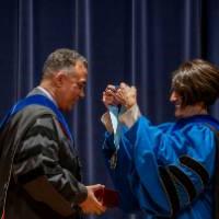 Provost giving a medallion to a faculty member